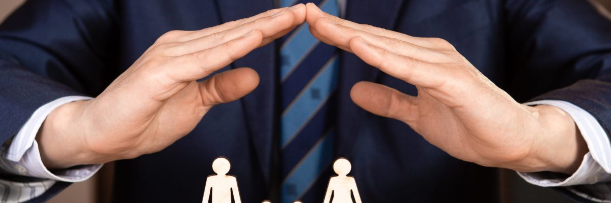A man in a suit holds hands in the shape of a house over the family. Insurance concept.